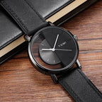 Black wristwatch with leather strap on a wooden surface