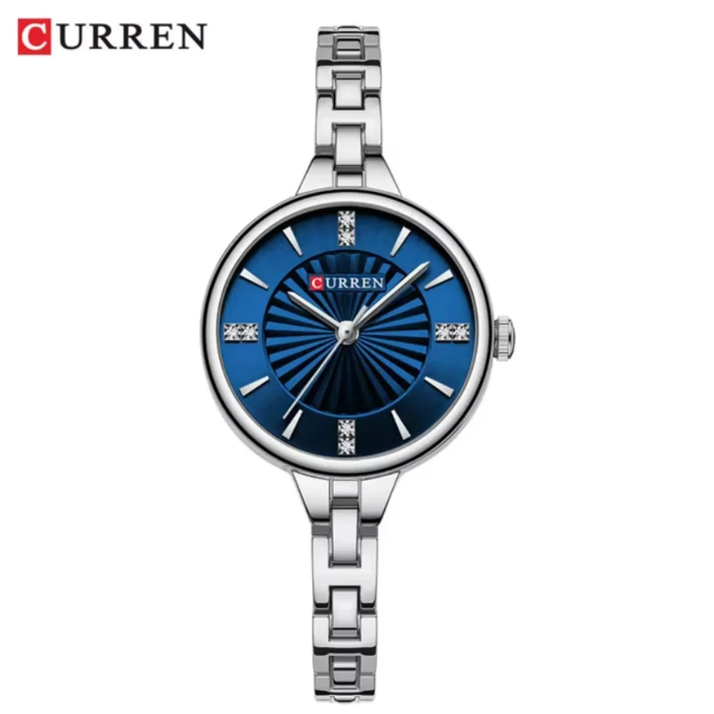 Curren 9097 Silver Blue women’s watch featuring a slim round dial and stainless steel band, presented by Zuri Blooms