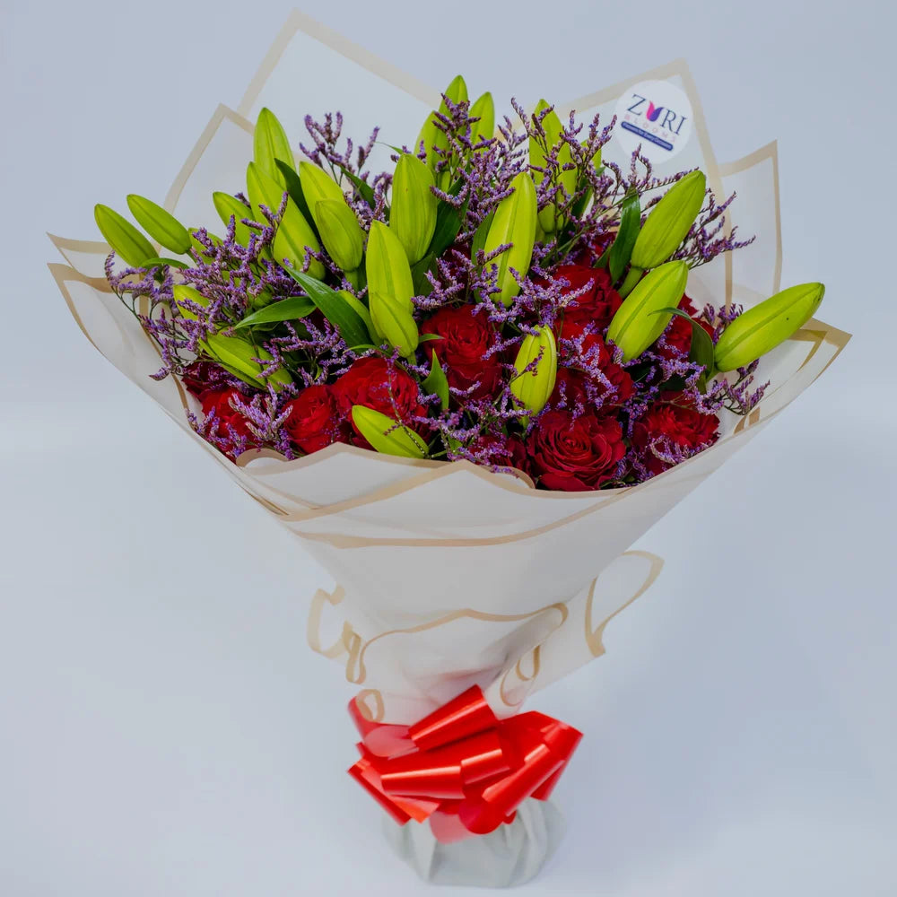 Glamorous Ensemble bouquet featuring red roses, lilies, and purple limonium top, arranged by Zuri Blooms