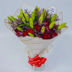 Glamorous Ensemble bouquet featuring red roses, lilies, and purple limonium top, arranged by Zuri Blooms