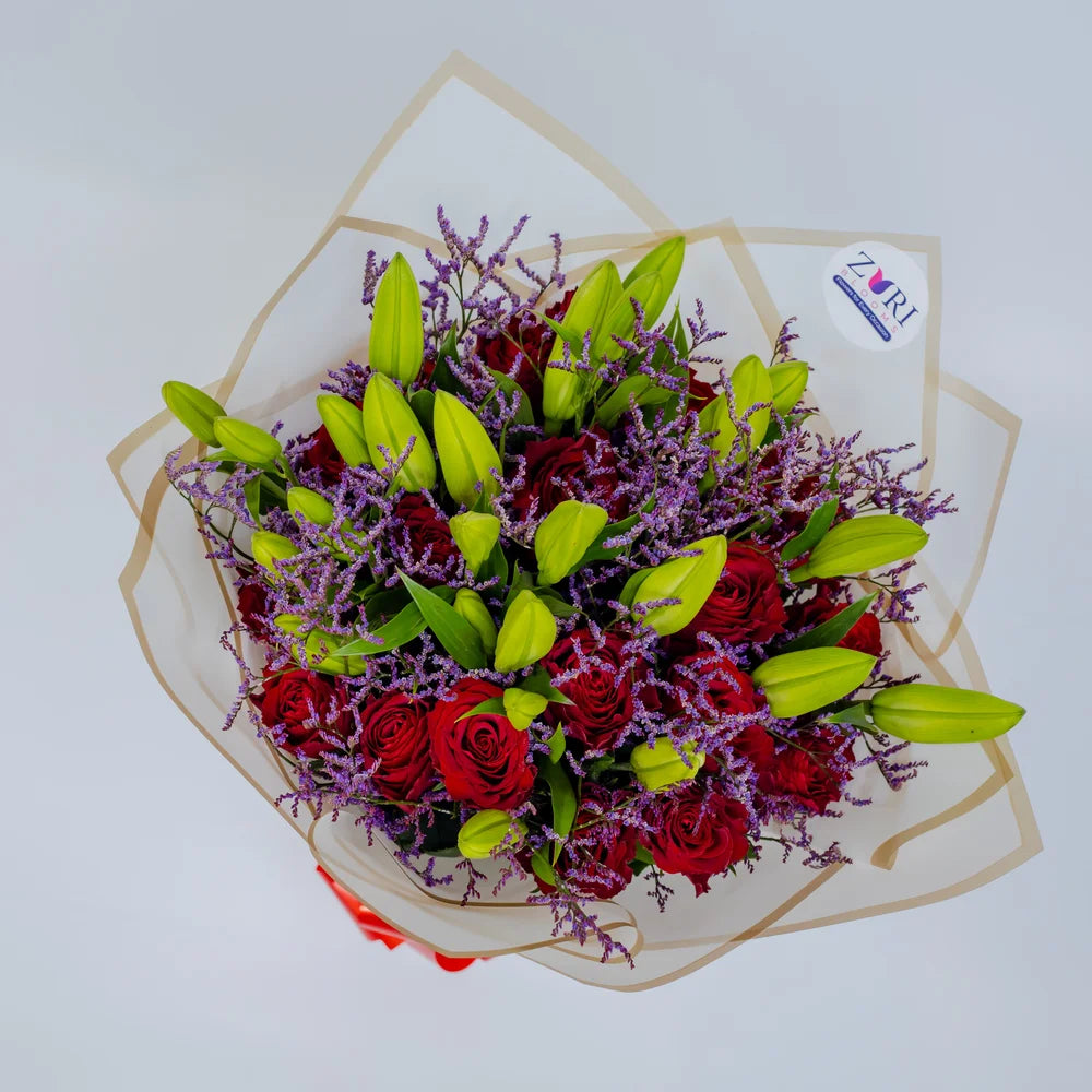 Glamorous Ensemble bouquet featuring red roses, lilies, and purple limonium front, arranged by Zuri Blooms