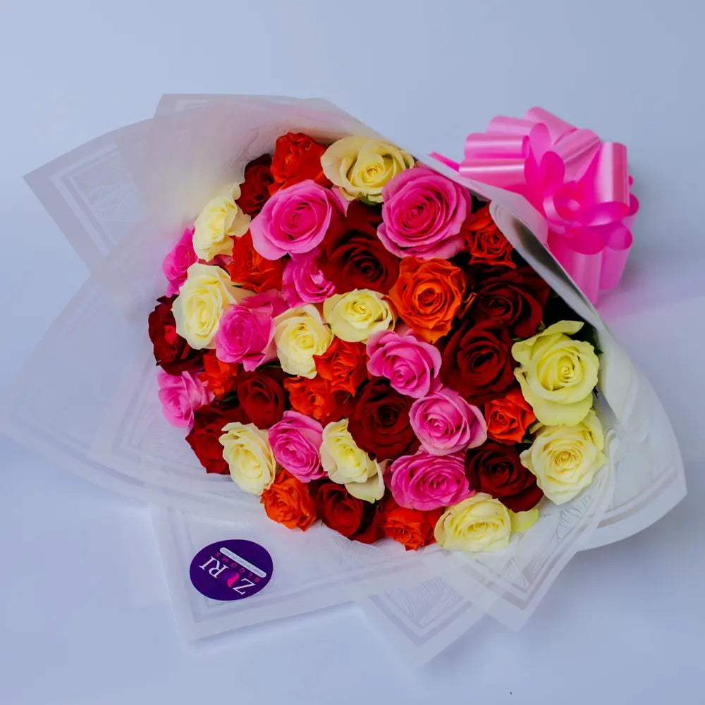 Mixed roses bouquet featuring a blend of red, pink, white, orange and yellow roses, arranged by Zuri Blooms