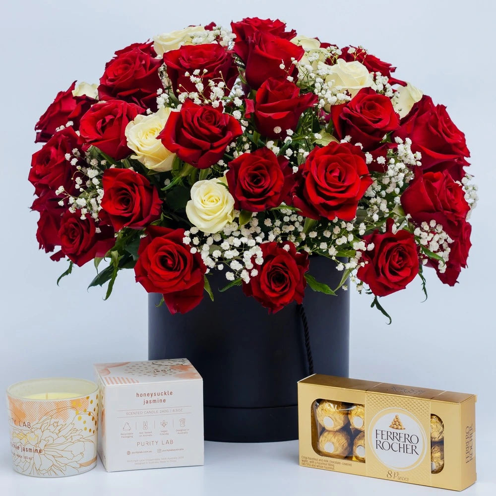 Eternal Embrace gift box featuring red and white roses, chocolates, and a scented candle arranged in a luxury box, curated by Zuri Blooms