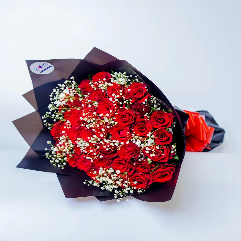 Romantic Rendezvous bouquet featuring red roses and white gypsophila, arranged by Zuri Blooms