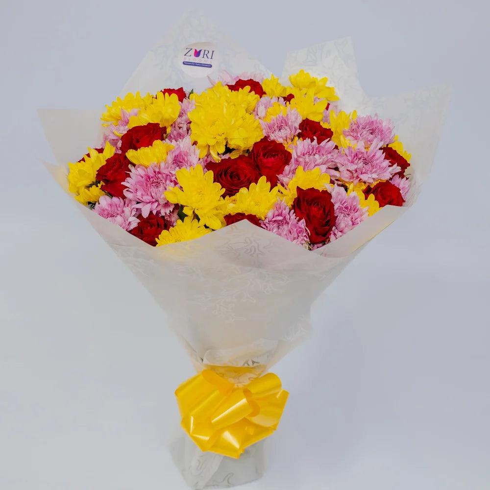 Sunset Charm bouquet featuring red roses with pink and yellow mums, arranged by Zuri Blooms
