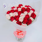 Sweetheart Symphony bouquet featuring red roses and baby pink roses, arranged by Zuri Blooms